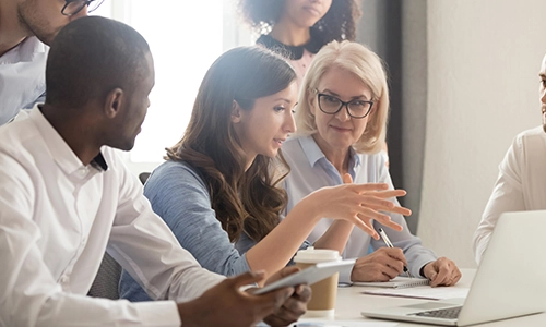Multiple people looking at a laptop