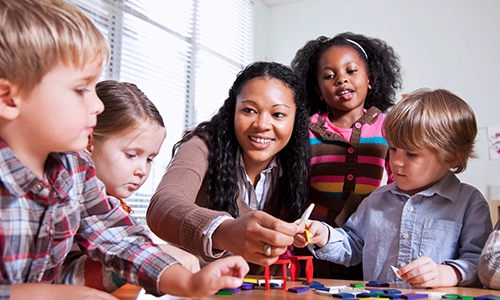 A woman surrounded by children in a child care setting