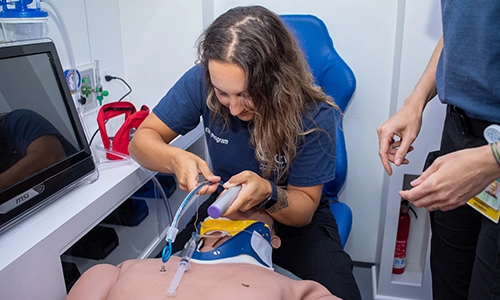 An EMS student using a medical practice dummy