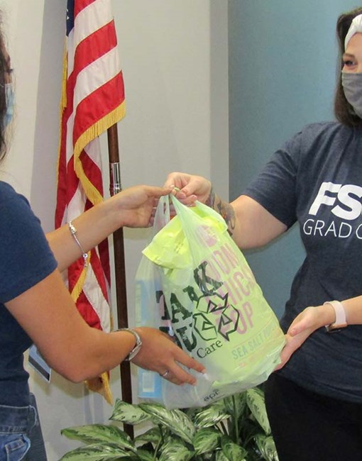 A person handing a bag to another
