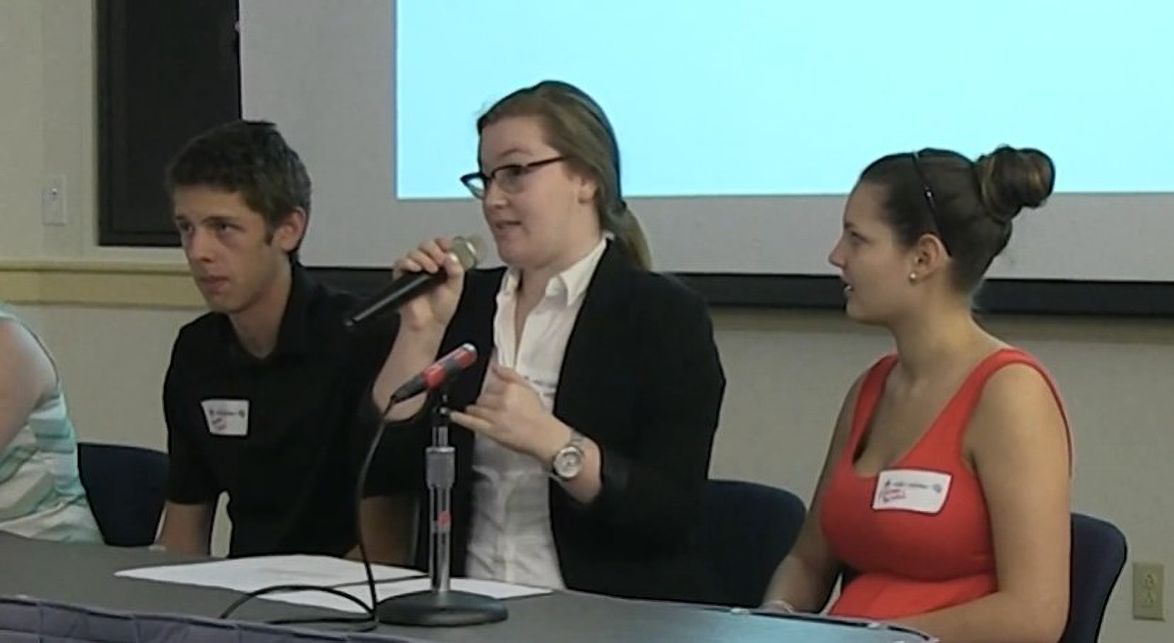 Screenshot from video of panel presentation at Student Research Conference with student Brittany Wielgosz speaking into mic.