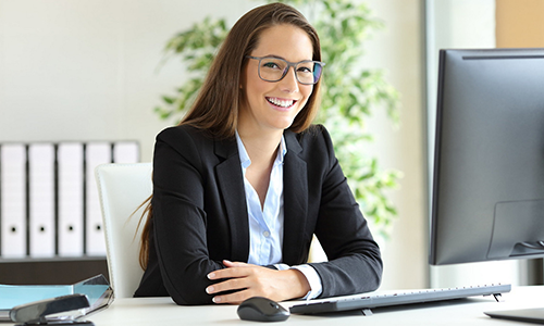 A smiling woman behind a computer
