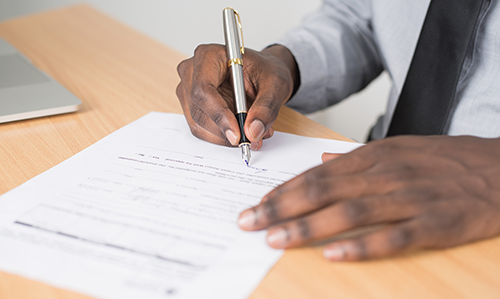 Close up of a person signing a document