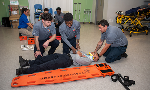 EMS students placing another student on a backboard