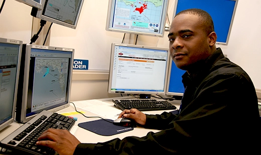 Man at computer screen looking at camera