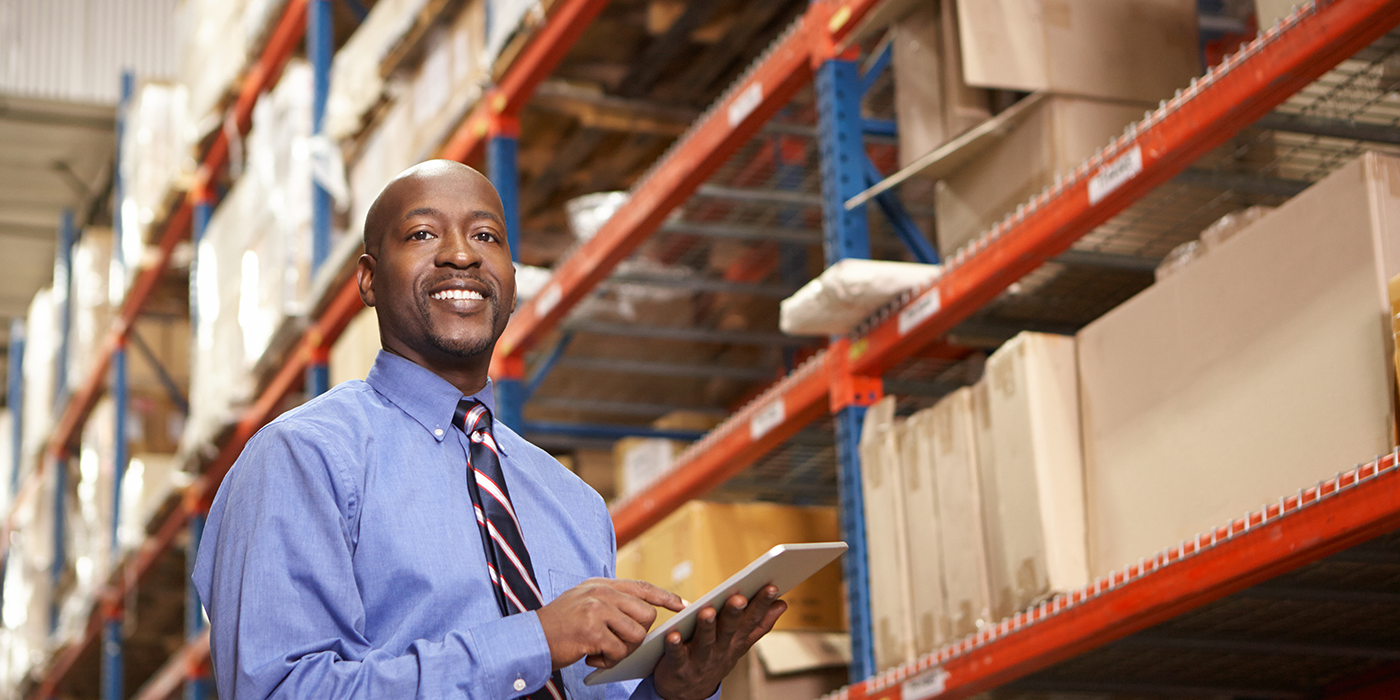 A man with a tablet in a warehouse