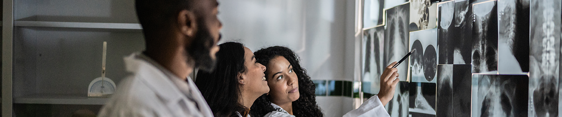 3 medical professionals analyzing x-rays