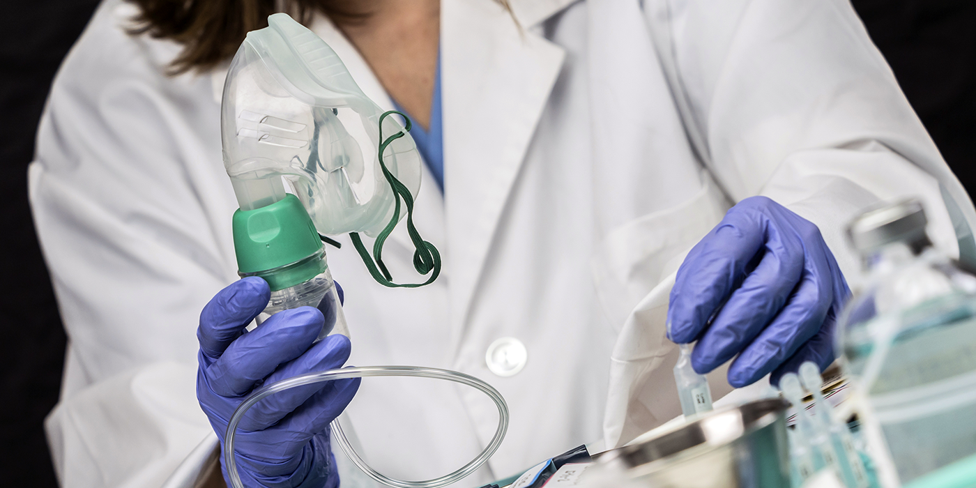 A person holding an anesthetic mask