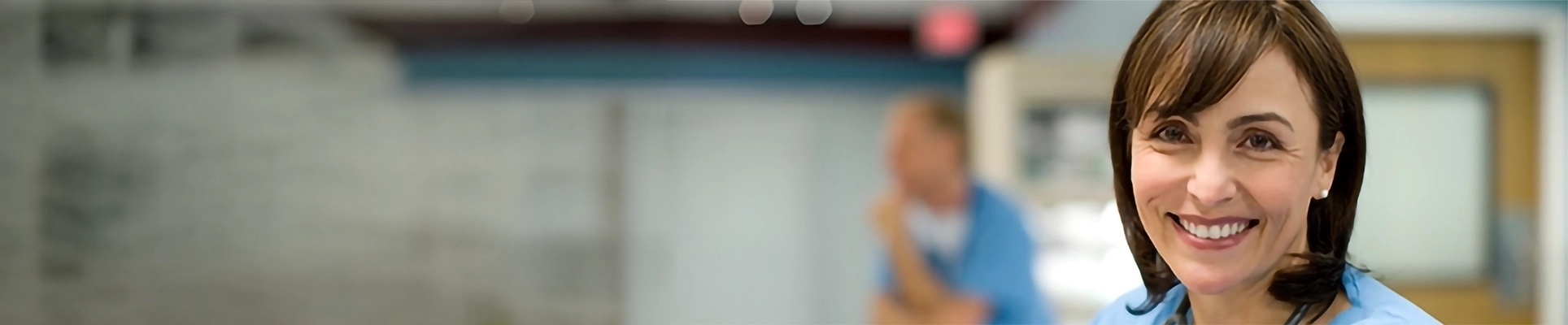 A smiling woman in medical scrubs