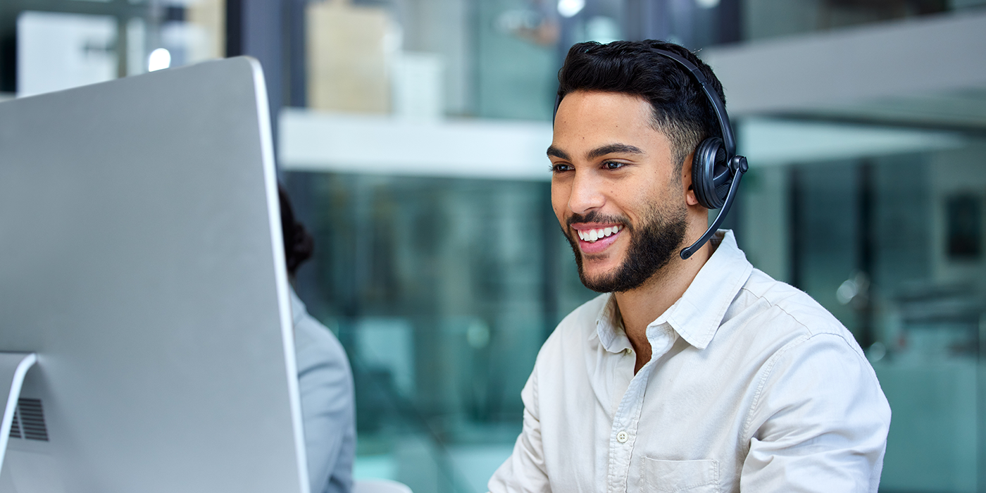A man with a headset on a computer