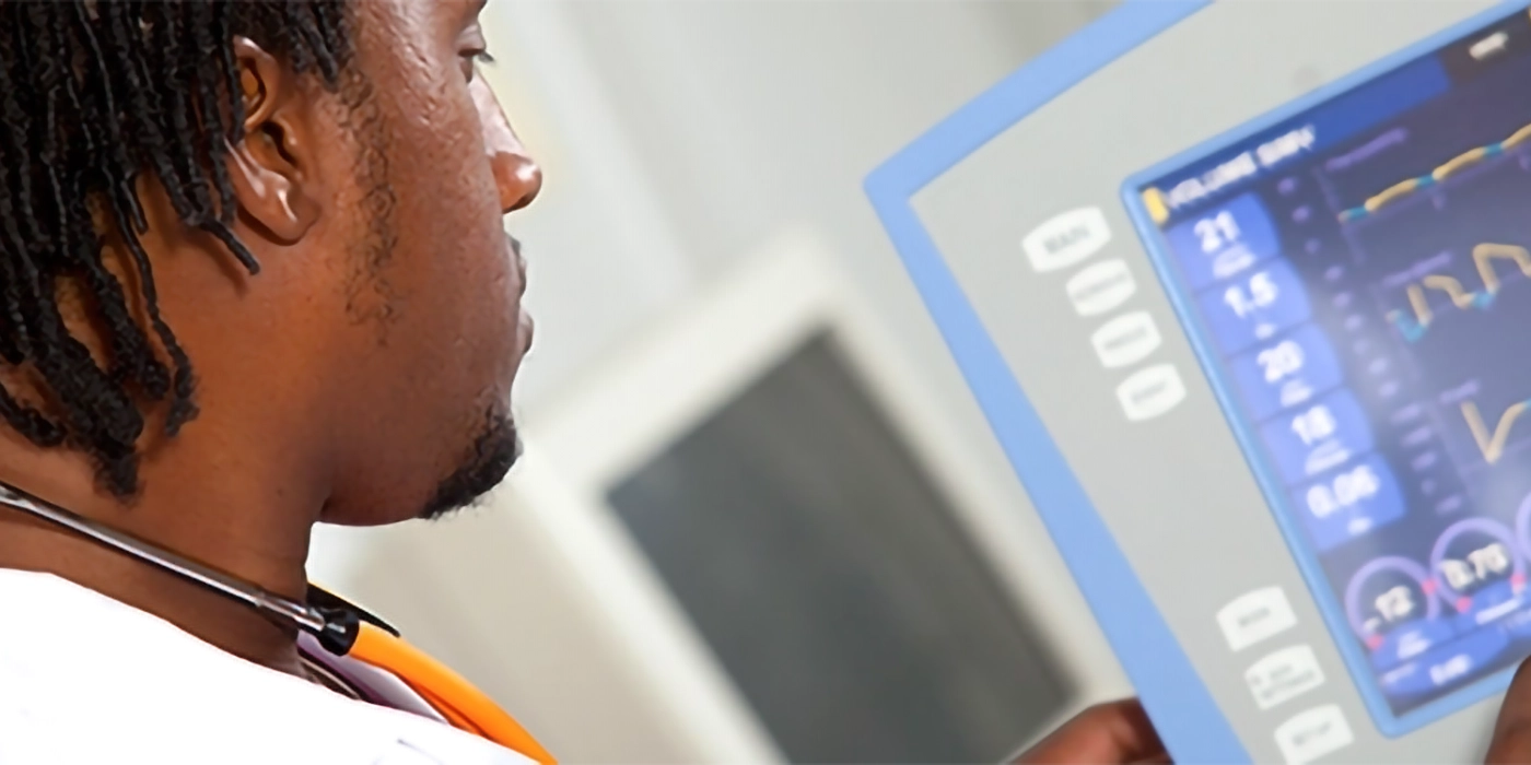A man looking at a medical readout screen