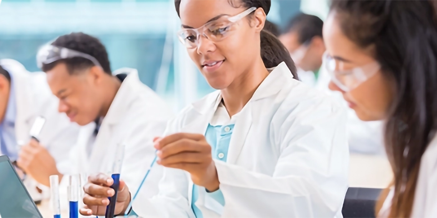 A person in a lab coat holding a test tube