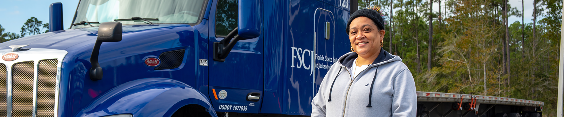 A woman in front of a semi truck