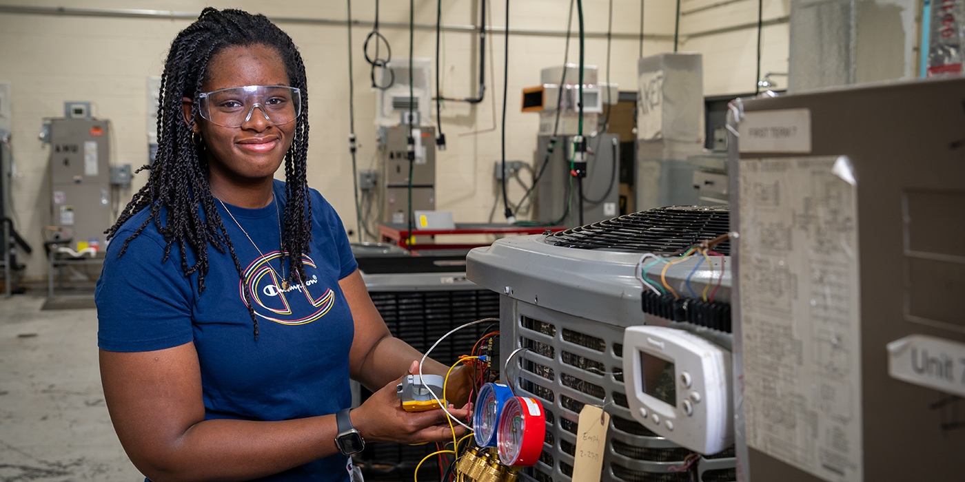 A woman working on an air conditioning unit
