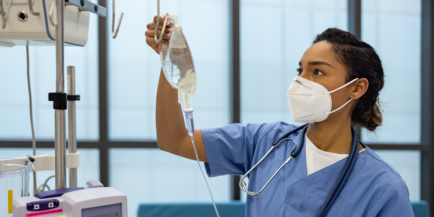 A medical professional hanging an IV bag