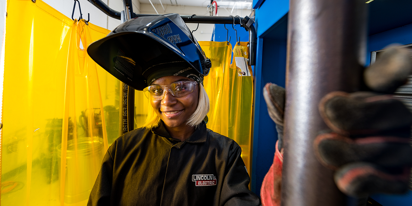 A woman in full protective welding gear