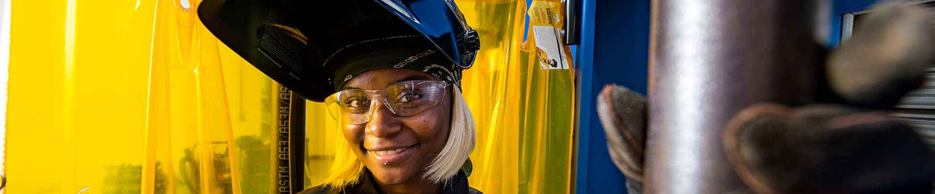 A woman in full protective welding gear