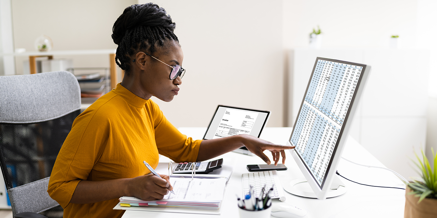 A person looking at spreadsheets on a computer
