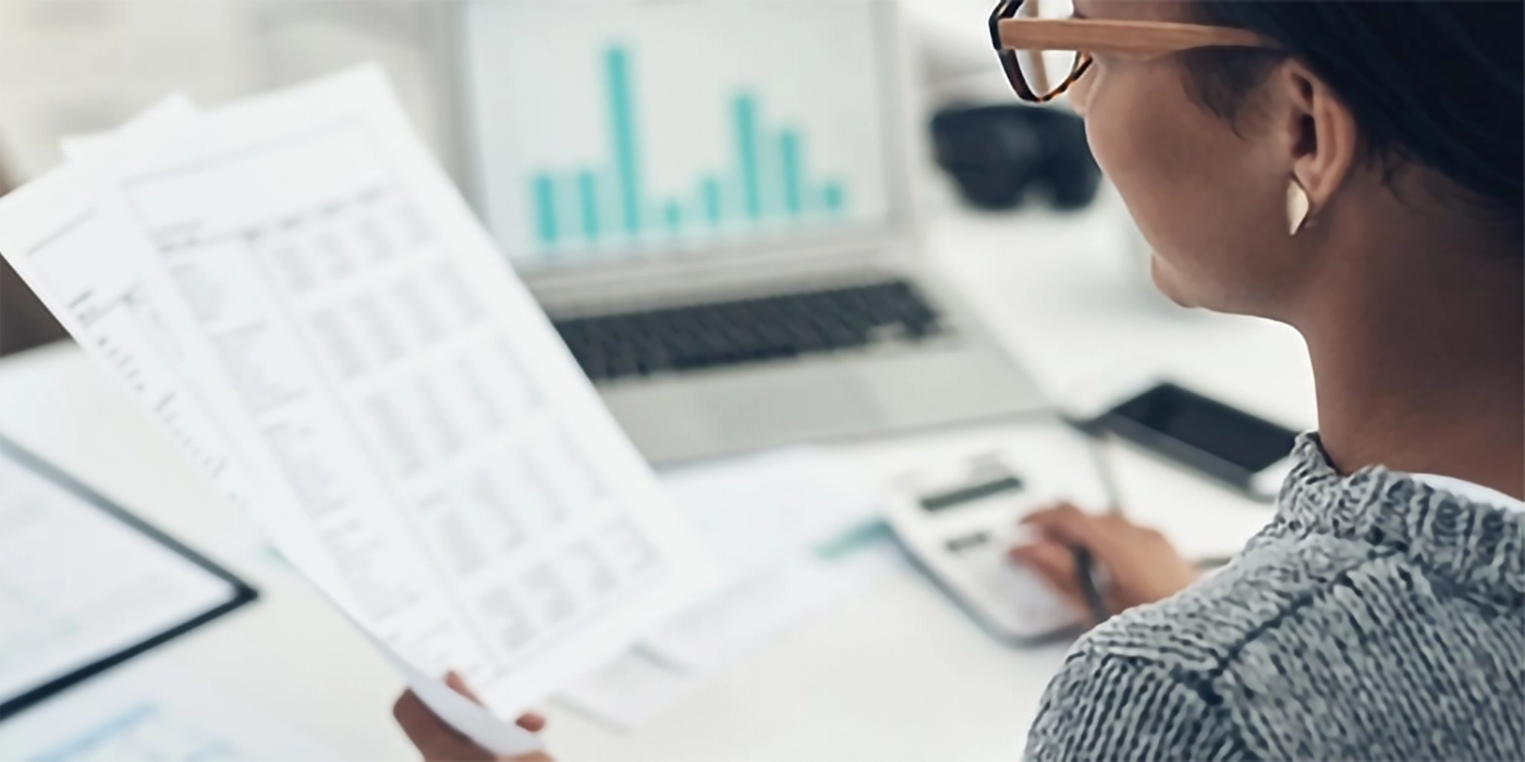 A woman looking at papers and using a calculator