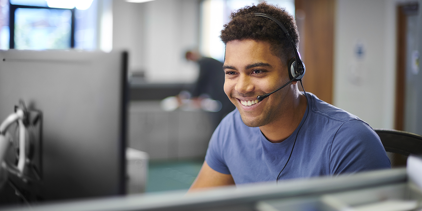 A man with a headset in front of a computer