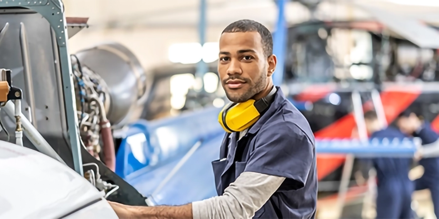 A man with earmuffs working on machinery