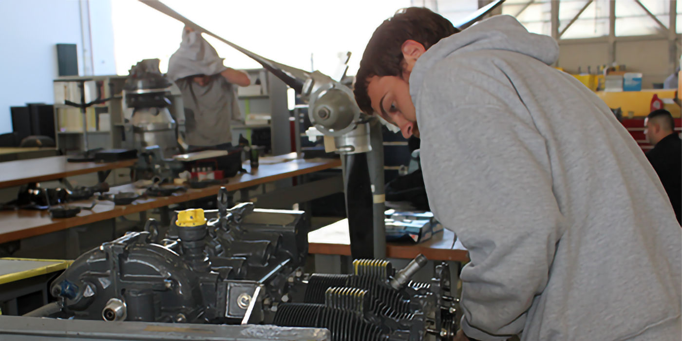 A man working on a small aircraft engine