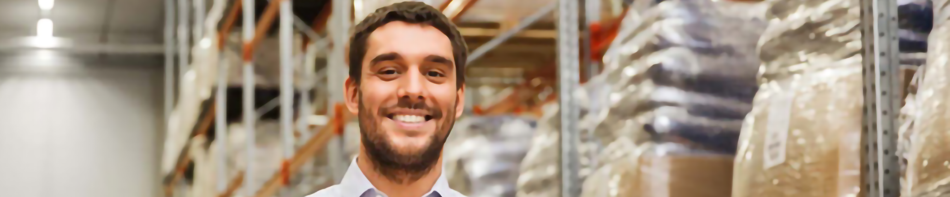 A a man holding a cardboard box in a large warehouse