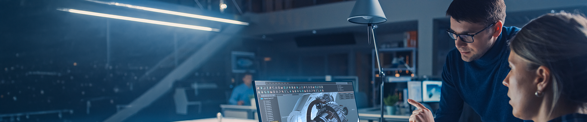 People looking at a computer with a model of complex machinery on the screen