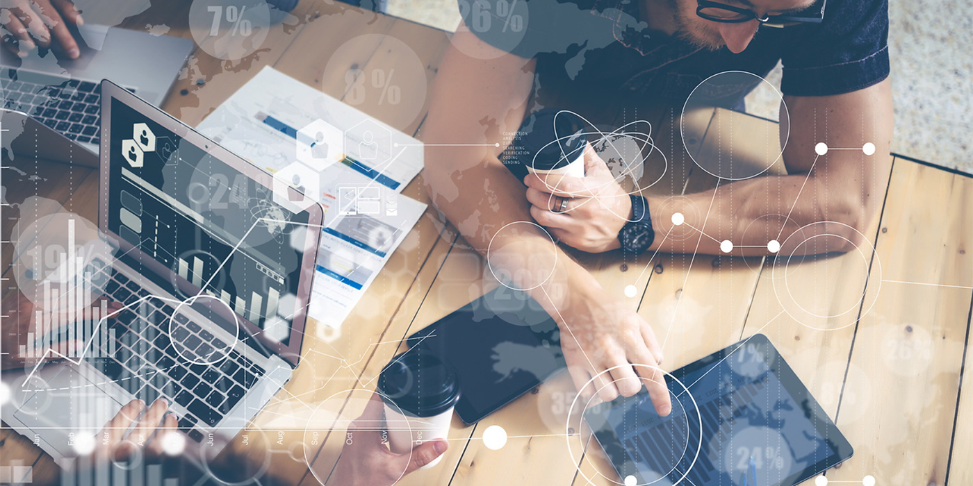 People working on laptops and tablets with various graphical overlays