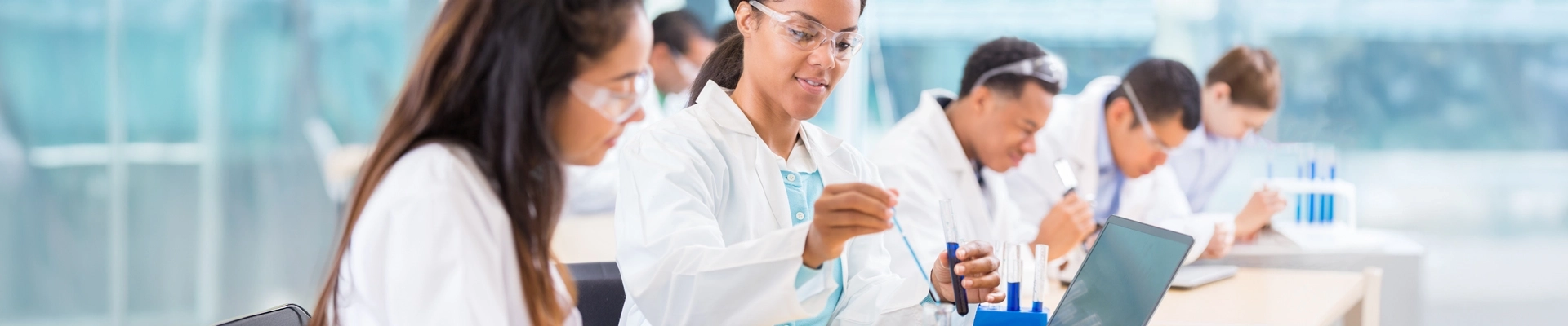 A person in a lab coat holding a test tube