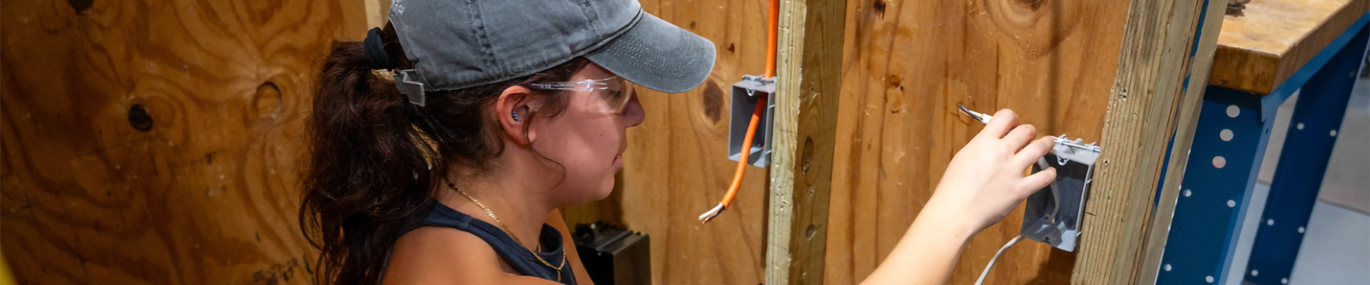 An electrician working on wiring an outlet box