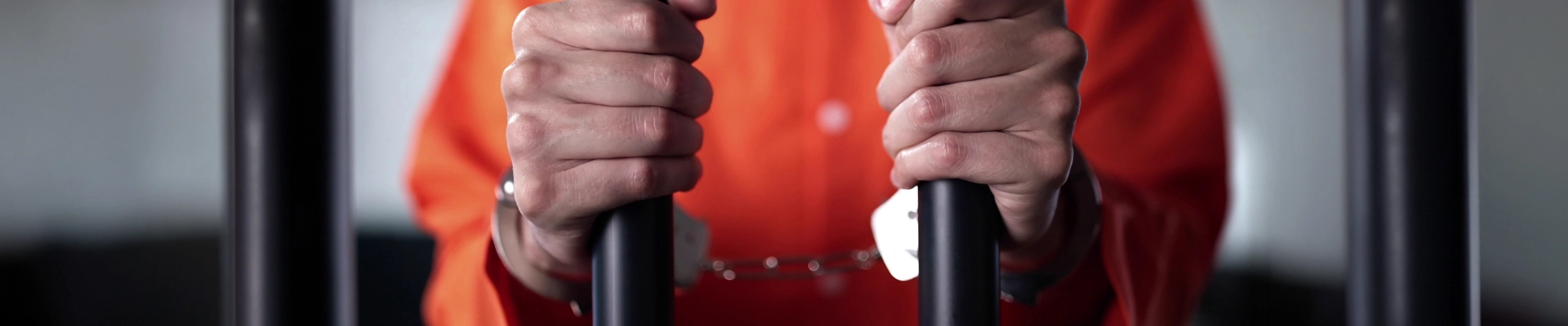 An inmate holding jail cell bars