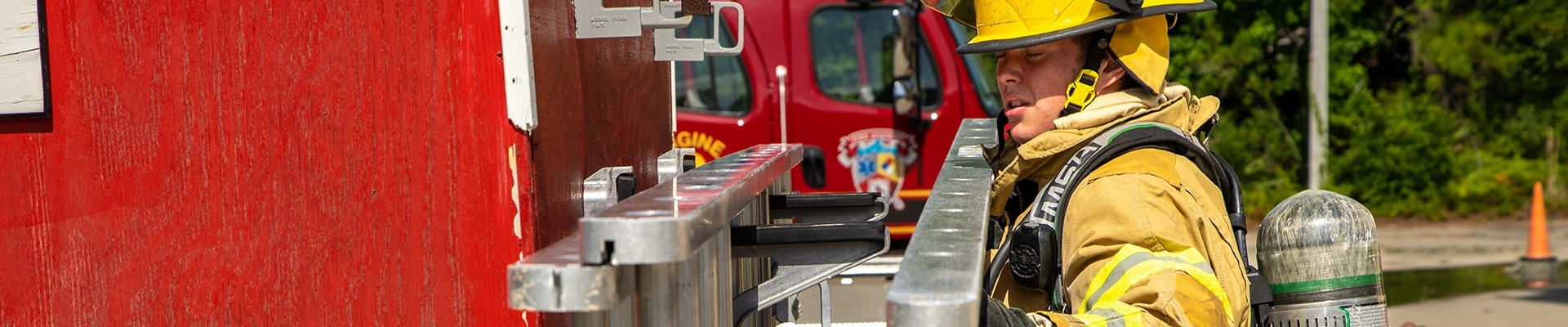 A firefighter removing a ladder from a fire truck