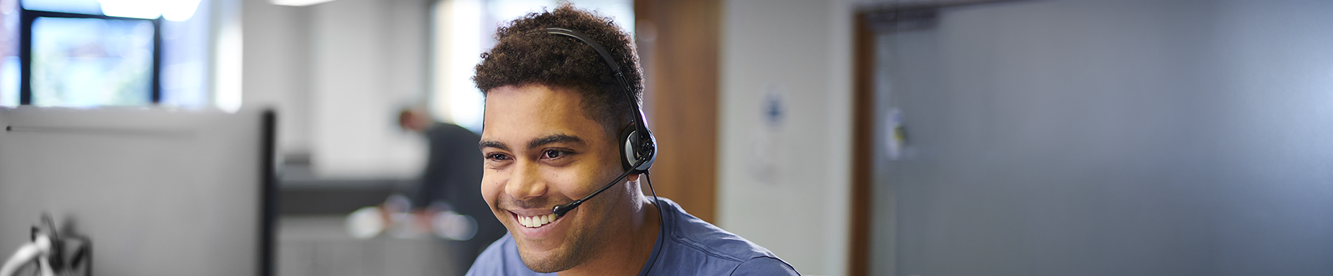 A man with a headset in front of a computer