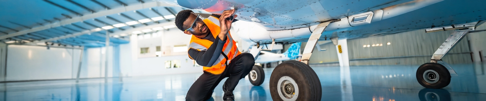 A man in a safety vest working on an airplane
