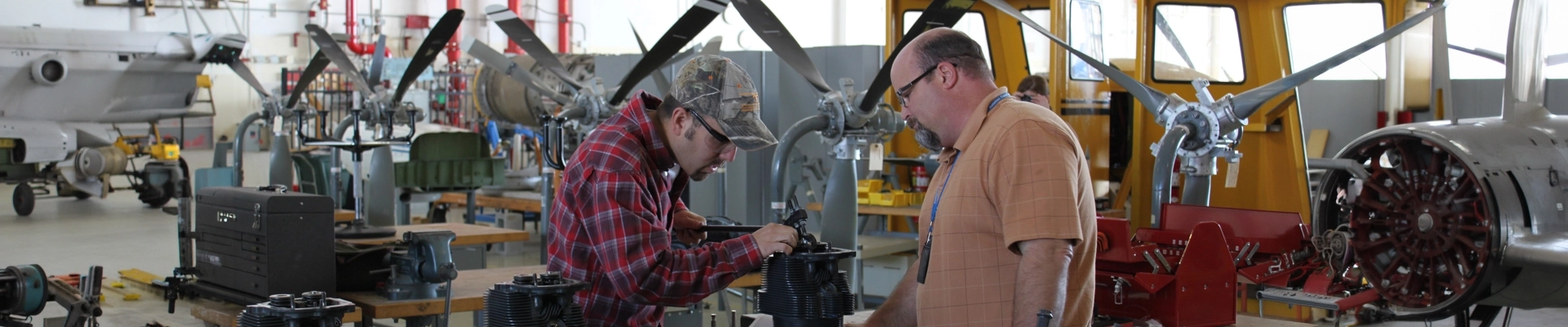 A man working on a small aircraft engine
