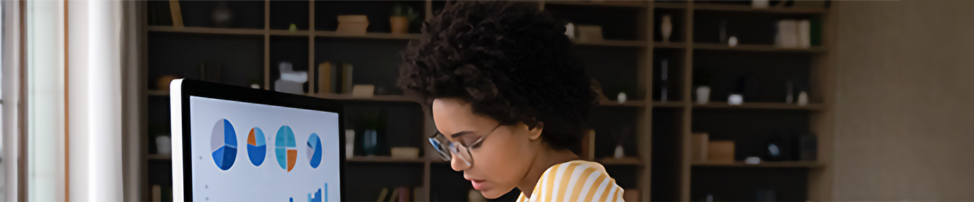 A woman using a computer with various charts on the screen