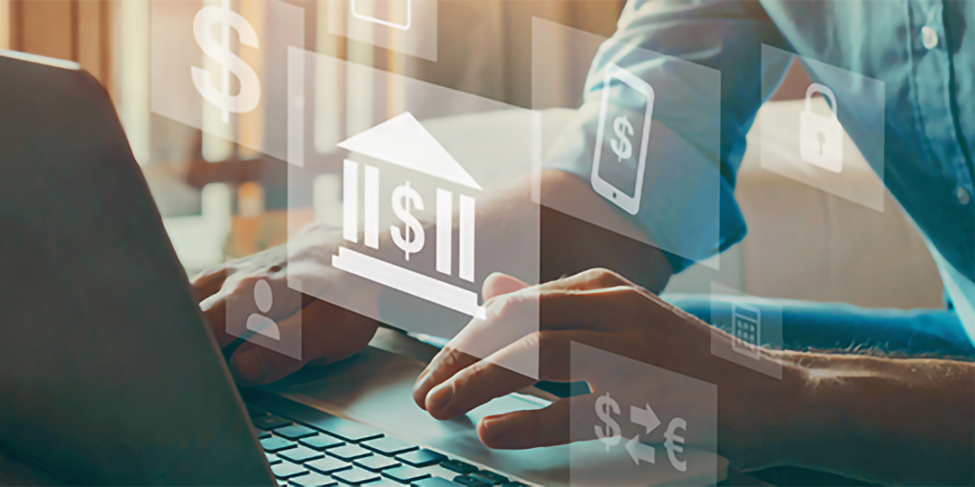 A person using a laptop with graphical overlays of finance symbols