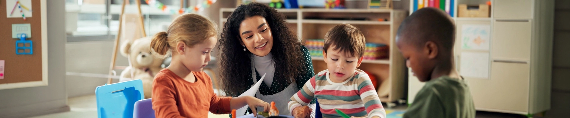 A woman interacting with young children in an educational setting