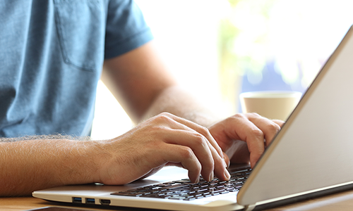 Close up of hands typing on a laptop