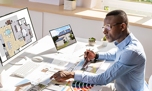 A man looking at architectural drawings on a computer