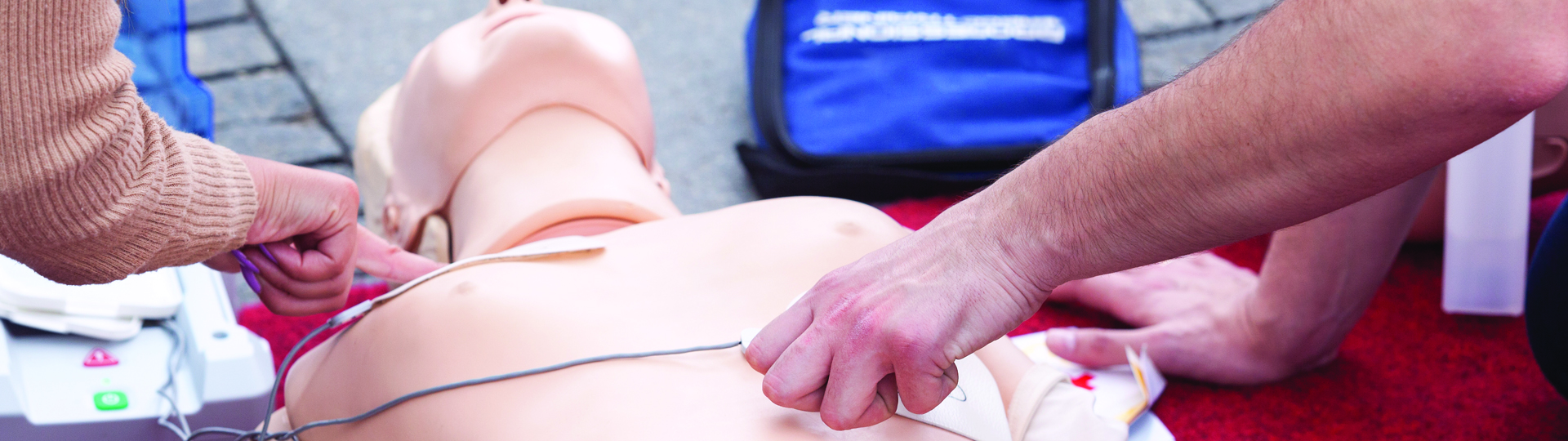 People using an AED on a practice dummy